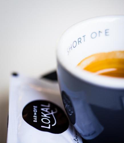 a cup of coffee sitting on top of a newspaper at One Suite Hotel in Mlini