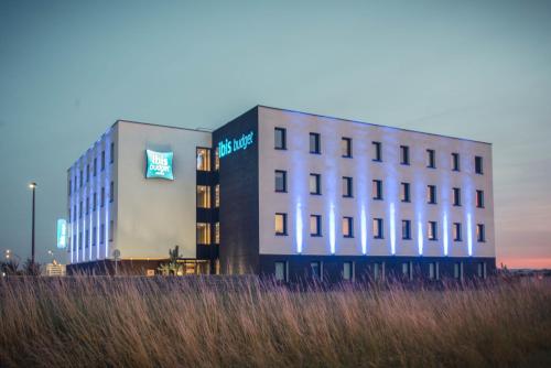 a building with a sign on the side of it at ibis budget Troyes Est in Saint-Parres-aux-Tertres