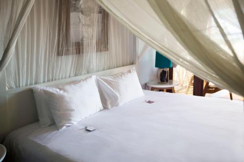 a bed with white sheets and pillows in a bedroom at Sentidos Beach Retreat in Miramar