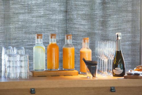 a group of bottles and glasses on a wooden shelf at One Suite Hotel in Mlini