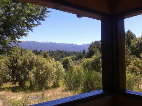 a view of a forest from a window at Del Viejo Camino in El Bolsón