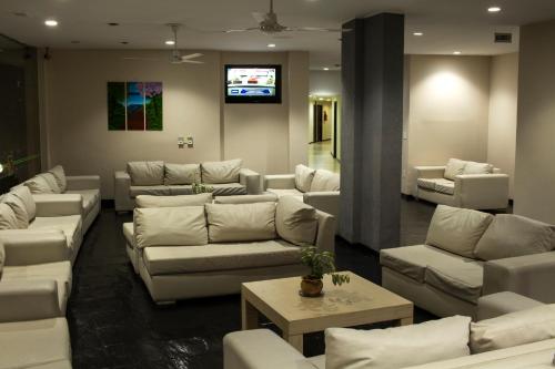a living room with white couches and a tv at Hotel El Libertador in Puerto Iguazú
