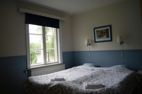 a bedroom with a bed and two windows at Lugnet Malung Hotell in Malung