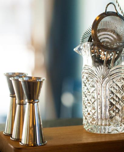 a silver pitcher and two silver cups on a table at One Suite Hotel in Mlini