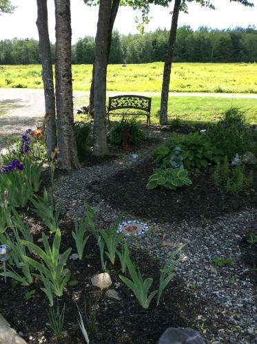 a bench in a park with flowers and trees at Blueberry Fields Bed & Breakfast in Jefferson
