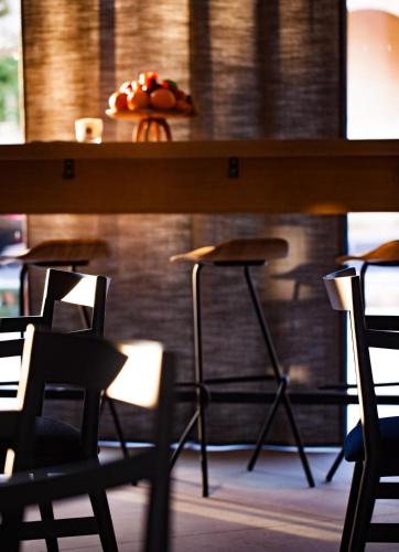 a bar with chairs and a table with a plate of food at One Suite Hotel in Mlini