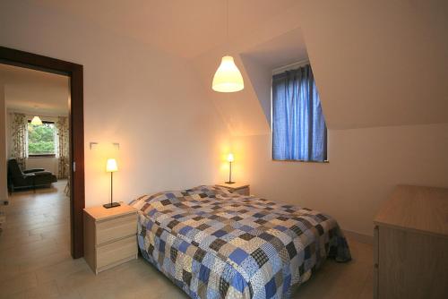 ヘルにあるBursztynowa 14 Helのベッドルーム1室(ベッド1台、ランプ2つ、窓付)