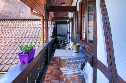 een balkon met een tafel en stoelen en een fiets bij Suites Residences Spa in Colmar