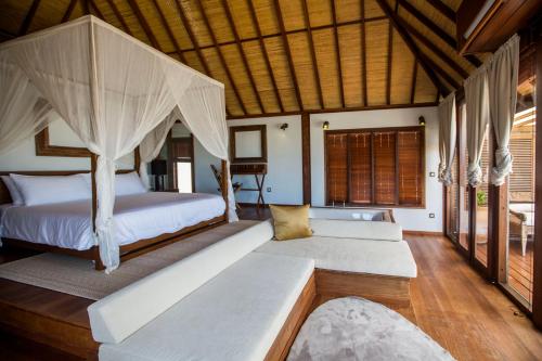 a bedroom with a bed and a couch in a room at Sentidos Beach Retreat in Miramar
