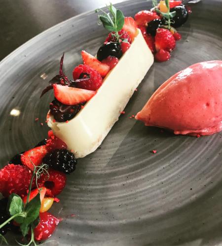 a piece of cake with fruit on a gray plate at Hotel & Restaurant Heyligenstaedt in Gießen
