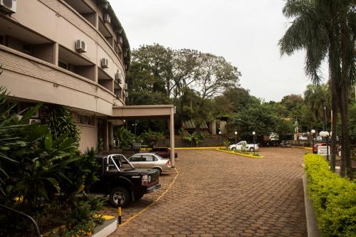 a parking lot in front of a building with cars parked at Hotel El Libertador in Puerto Iguazú