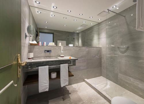 a bathroom with a sink and a shower at Boutique Hotel Sunstar Brissago am Lago Maggiore in Brissago