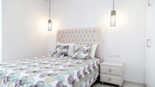 a white bedroom with a large bed and two pillows at Liberte Maisonettes in Parga