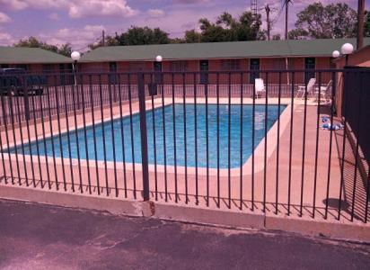 a large swimming pool behind a metal fence at Western Inn Hamilton in Hamilton