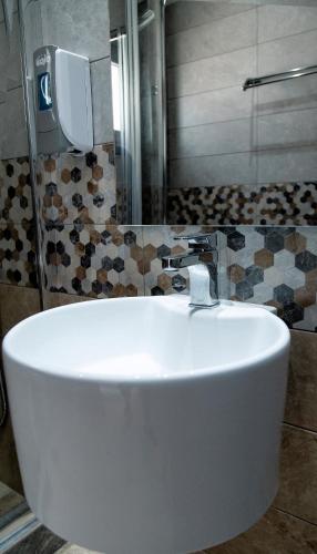 a white sink in a bathroom with a shower at Liberte Maisonettes in Parga