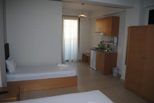 a small room with a bed and a kitchen at Niriides Studios and Apartments in Paralia Katerinis