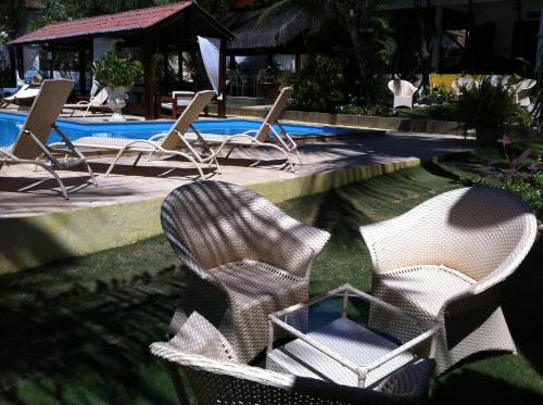a group of chairs sitting next to a swimming pool at Hotel e Pousada La Dolce Vita in Canoa Quebrada
