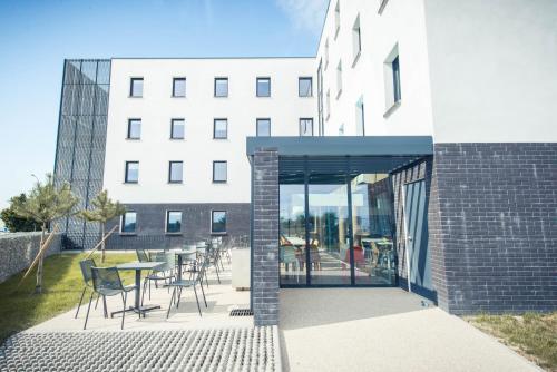 a patio with chairs and a table in front of a building at ibis budget Troyes Est in Saint-Parres-aux-Tertres