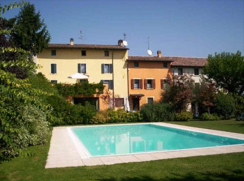 a villa with a swimming pool in front of a house at B&B Casale Onida in Volta Mantovana