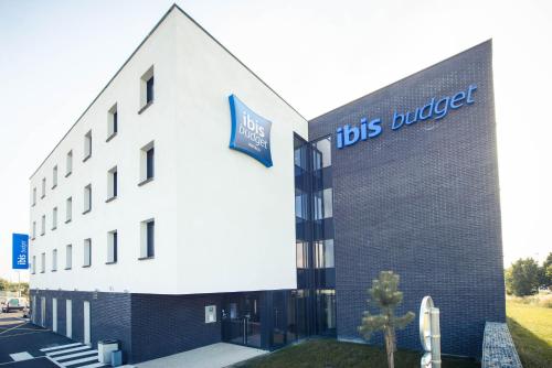 a building with a tds bucket sign on it at ibis budget Troyes Est in Saint-Parres-aux-Tertres