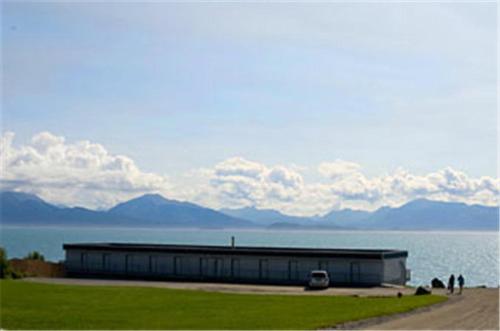 een groot gebouw naast een waterlichaam bij Ocean Shores Hotel in Homer