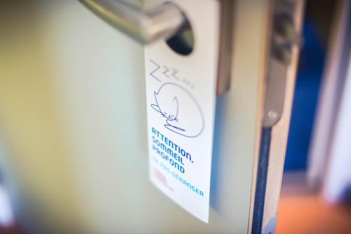 a close up of a sign on a door at ibis budget Troyes Est in Saint-Parres-aux-Tertres