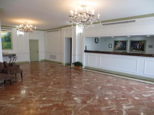 Großes Zimmer mit Marmorboden und Kronleuchtern. in der Unterkunft Olive Tree Hotel and Banquet halls in Jackson
