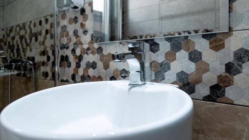 a white sink in a bathroom with a mirror at Liberte Maisonettes in Parga