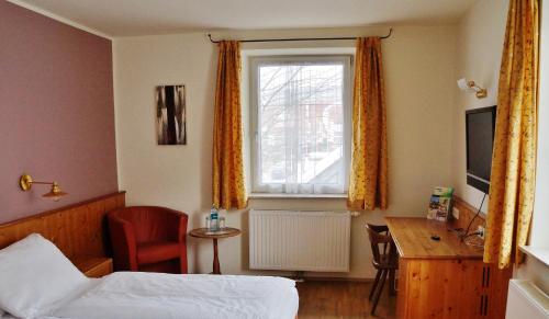 a bedroom with a bed and a window and a desk at Gasthof zur Strass in Eugendorf