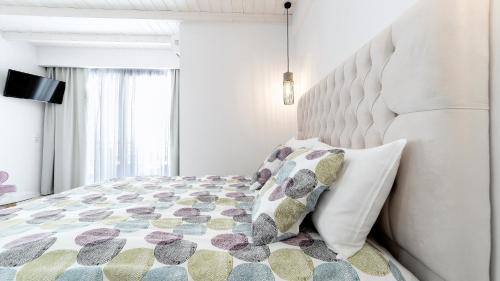 a white bedroom with a large bed with pillows at Liberte Maisonettes in Parga