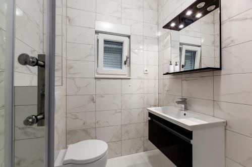 a bathroom with a toilet and a sink and a shower at Luxury Villa ARIA, Apartment in Trogir