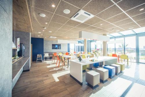an office with a dining area with tables and chairs at ibis budget Troyes Est in Saint-Parres-aux-Tertres