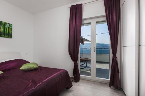 a bedroom with a bed and a sliding glass door at Luxury Villa ARIA, Apartment in Trogir