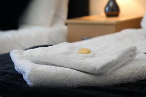 a stack of towels sitting on top of a bed at Townhead Apartments Gallery View in Paisley