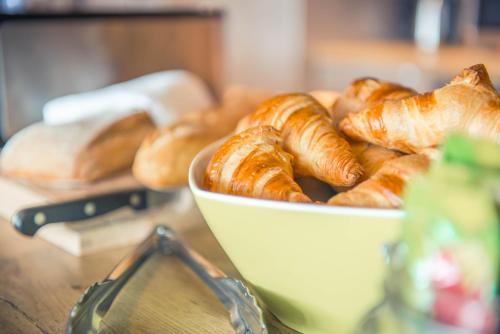 a bowl of croissants and pastries on a table at ibis budget Troyes Est in Saint-Parres-aux-Tertres