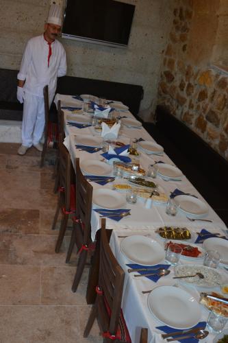 a chef standing in front of a long table at Yoruk Stone House in Nevsehir