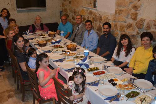 a group of people sitting around a table with food at Yoruk Stone House in Nevsehir