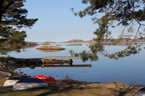 a dock on a lake with two boats in the water at Hällestrand Seaview Apartment in Strömstad