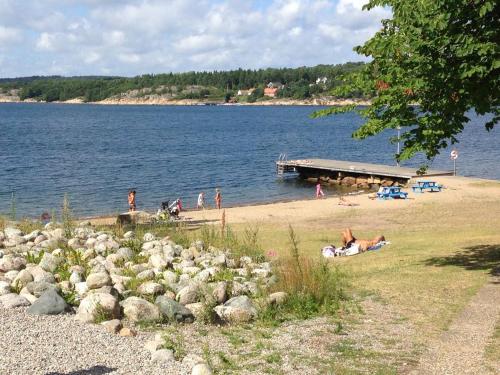 a group of people on a beach near the water at Hällestrand Seaview Apartment in Strömstad