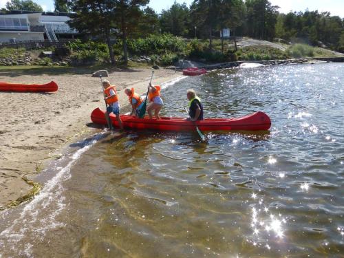 a group of people in a red canoe on a river at Hällestrand Seaview Apartment in Strömstad