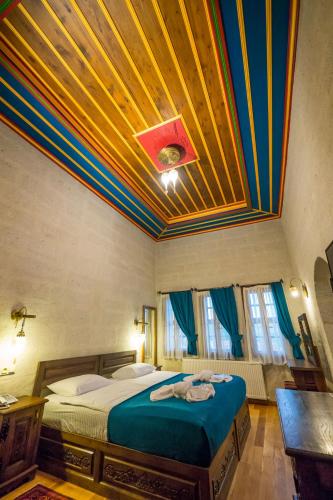 a bedroom with a large bed with a colorful ceiling at Yoruk Stone House in Nevsehir
