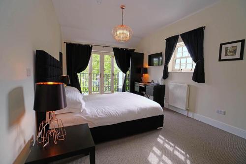 a bedroom with a bed and a table with a lamp at Greyhound Hever in Edenbridge