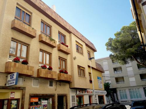 un bâtiment avec des boîtes de fleurs sur son côté dans l'établissement Apartamento Villananitos, à San Pedro del Pinatar
