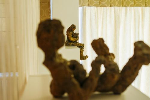 a statue of a man sitting on a window sill at La Casa dels Abeuradors in Gandesa