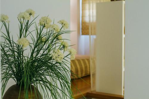 a vase filled with white flowers in a room at La Casa dels Abeuradors in Gandesa