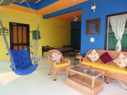 a living room with a swing and chairs at The Coral Tree Boutique Homestay in Agra