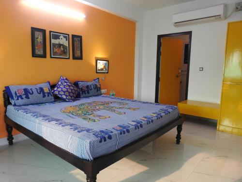 a bedroom with a bed with a blue comforter at The Coral Tree Boutique Homestay in Agra
