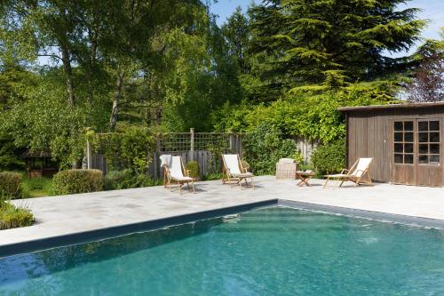 - une piscine avec des chaises et une maison dans l'établissement La Marcotte - Pierres d'Histoire, à Saint-Martin-en-Bière