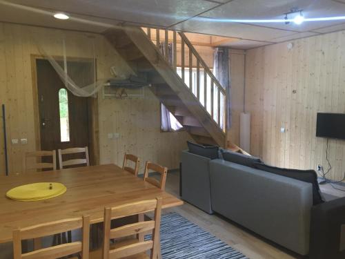 a dining room with a table and a staircase at Metsaääre Accommodation in Uulu