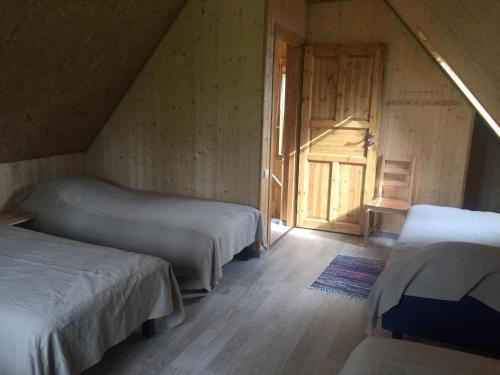a bedroom with two beds and a door to a room at Metsaääre Accommodation in Uulu